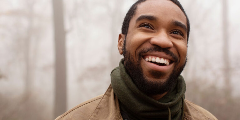 person smiling on a foggy day after creating a relapse prevention plan