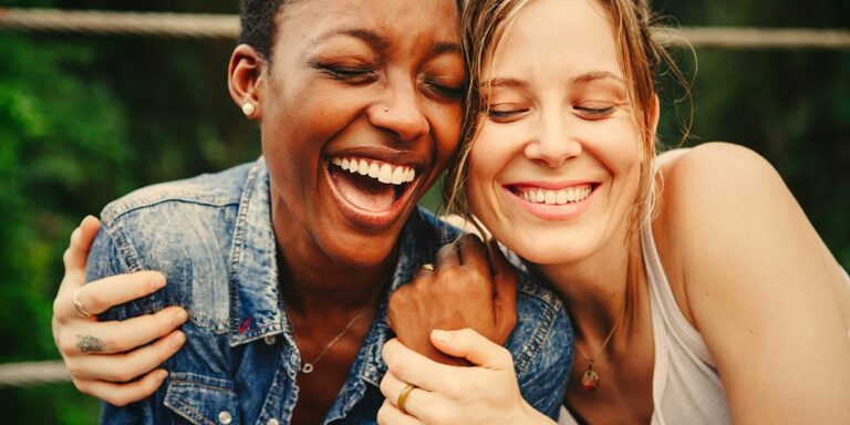 two women hugging and smiling while discussing how to quit alcohol safely