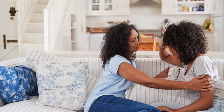 two women sitting on couch