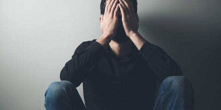 man sitting against the wall