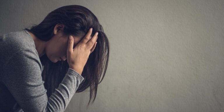 woman with head in hands considering the most addictive drugs in louisville