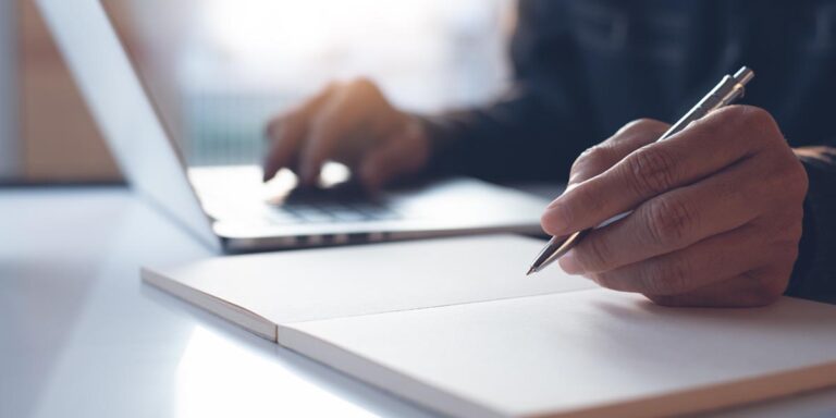 person on laptop taking notes about addiction recovery options in louisville