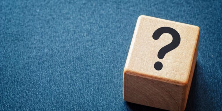 Wooden block with question mark on it on blue background as a symbol of questioning facts versus fiction about addiction and withdrawal.