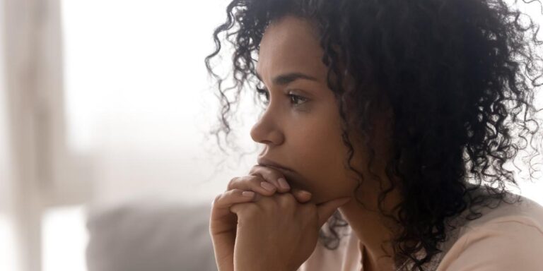 Person in brightly lit room looking pensive while considering the question what are the dangers of Vyvanse addiction