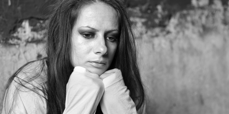 black and white photo of person resting chin against fists looking distressed while contemplating how long do withdrawals last