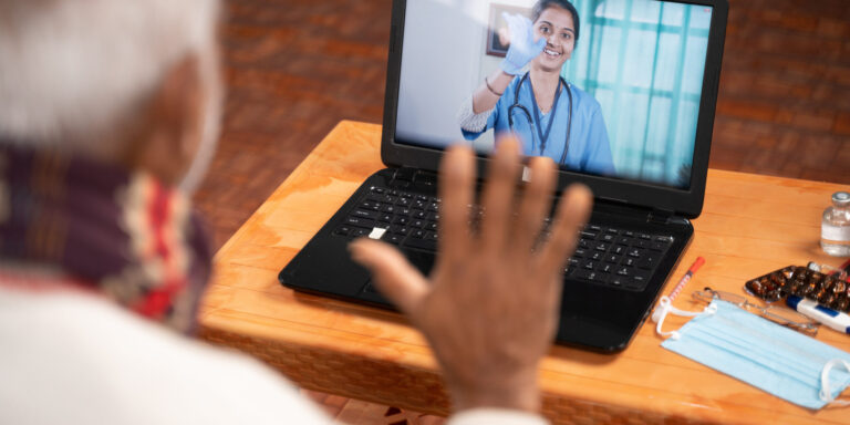 A man on video with his addiction treatment doctor using his laptop as part of his telehealth-based opioid treatment program