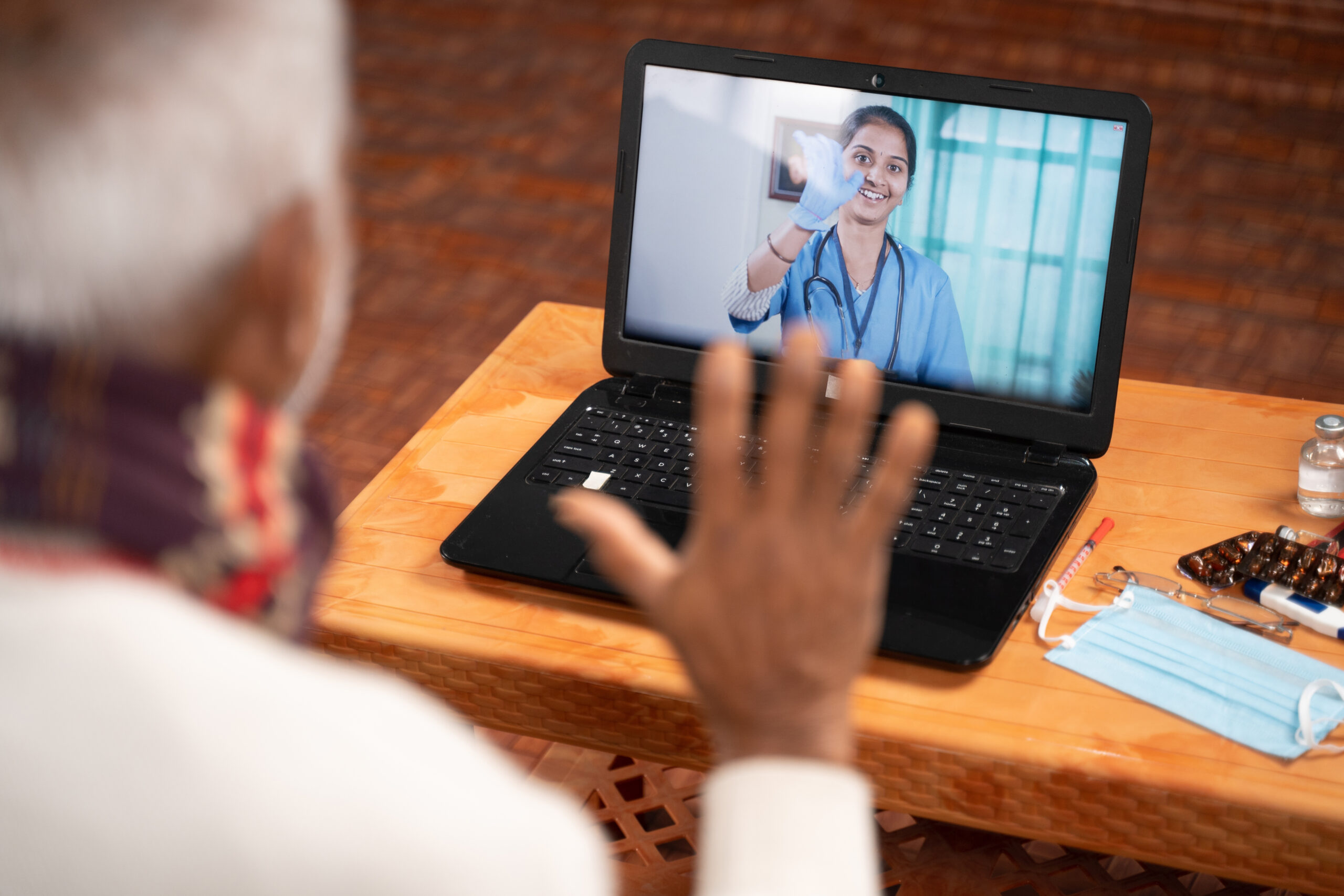 A man on video with his addiction treatment doctor using his laptop as part of his telehealth-based opioid treatment program