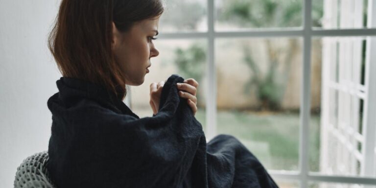 person sitting near window contemplating the dangers of fentanyl addiction