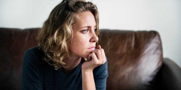 person sitting on couch thinking about how heroin addiction affects your health