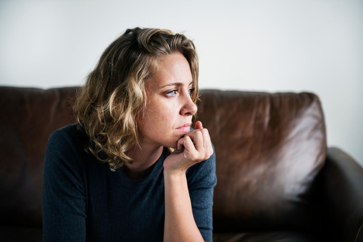 person sitting on couch thinking about how heroin addiction affects your health