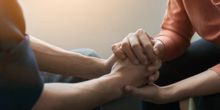 two people joining hands while discussing the importance of a relapse program