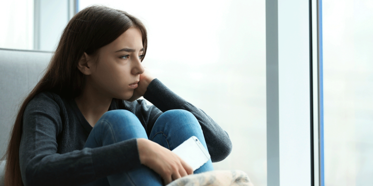 person sitting next to window struggling with long-term effects of meth addiction