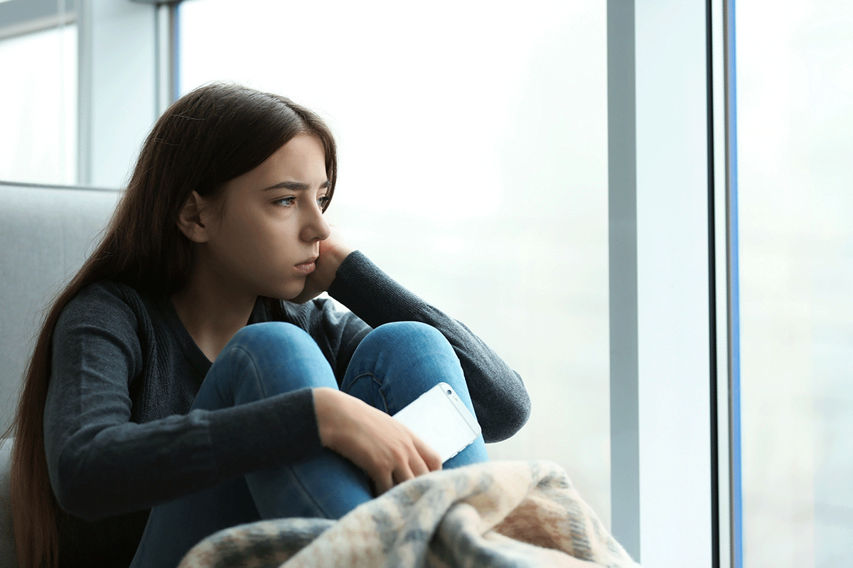 person sitting next to window struggling with long-term effects of meth addiction